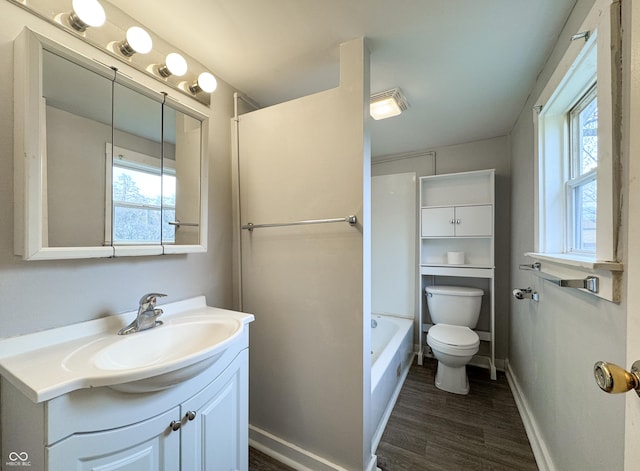 bathroom featuring wood-type flooring, vanity, toilet, and a healthy amount of sunlight