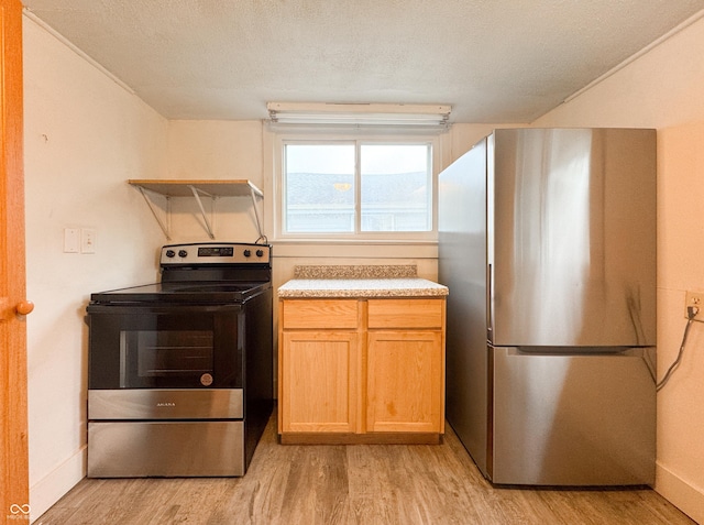 kitchen featuring appliances with stainless steel finishes, a textured ceiling, light hardwood / wood-style floors, and light brown cabinets