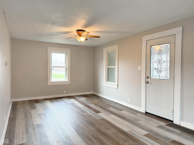 foyer featuring ceiling fan, light hardwood / wood-style floors, and a textured ceiling