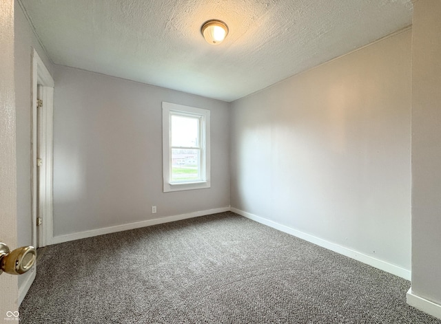 empty room featuring carpet and a textured ceiling