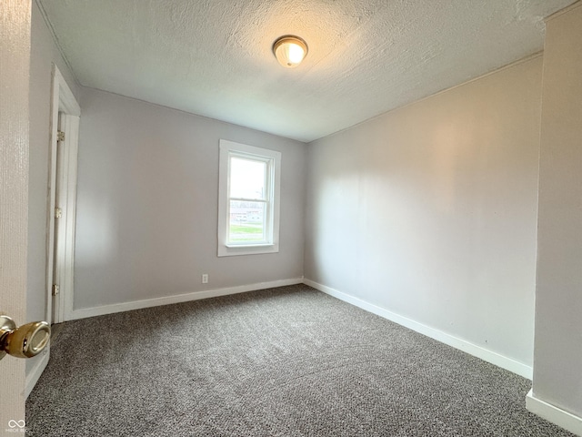 empty room featuring a textured ceiling and carpet floors