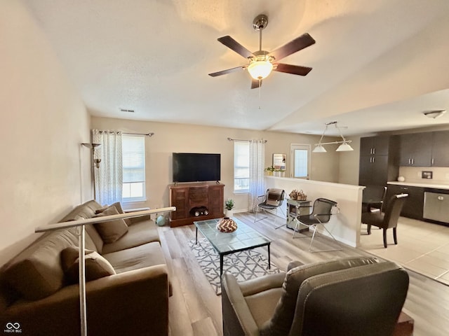 living room featuring light hardwood / wood-style floors, a wealth of natural light, lofted ceiling, and ceiling fan