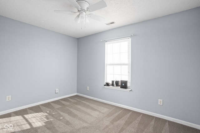 carpeted spare room with ceiling fan and a textured ceiling