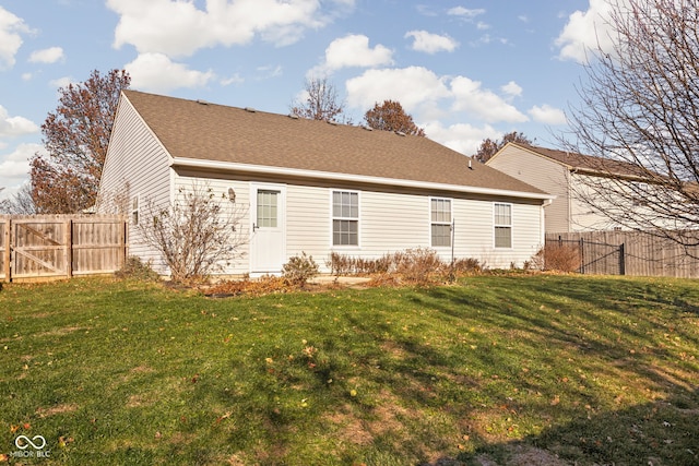 rear view of property featuring a yard