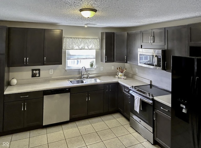 kitchen with sink, light tile patterned flooring, a textured ceiling, and appliances with stainless steel finishes