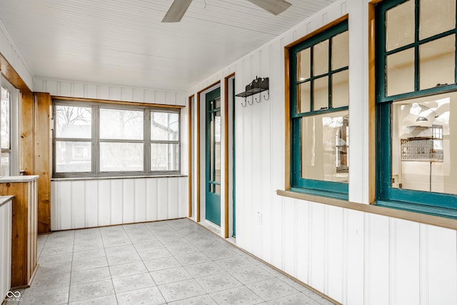 unfurnished sunroom featuring ceiling fan