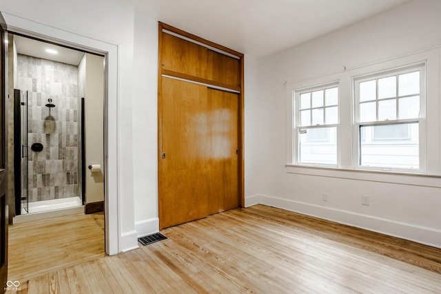 unfurnished bedroom with a closet and light hardwood / wood-style floors