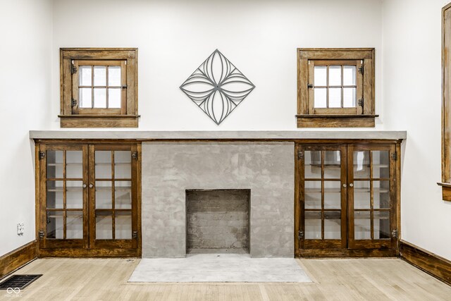 interior details featuring a fireplace, french doors, and wood-type flooring