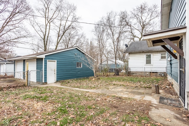 view of yard with a garage and an outbuilding