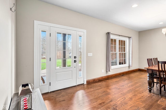 foyer entrance with hardwood / wood-style flooring and a wall unit AC