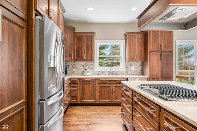 kitchen with plenty of natural light, custom range hood, sink, and appliances with stainless steel finishes