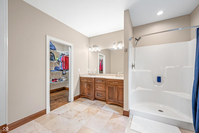 bathroom featuring a shower and vanity