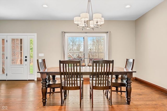 dining room featuring wood-type flooring and an inviting chandelier