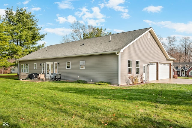 rear view of house with a lawn, a patio area, and a garage