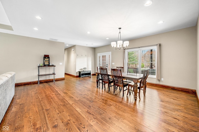 dining area featuring an inviting chandelier and light hardwood / wood-style flooring