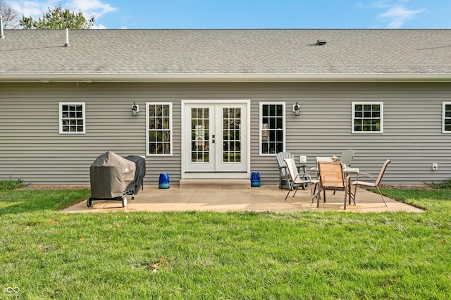 rear view of house with a lawn, french doors, and a patio