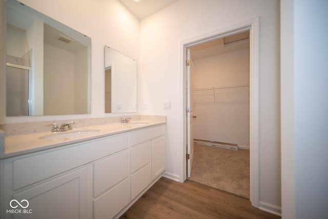 5607 Tart Blvd, Indianapolis, IN 46239 - full bathroom with double vanity, a shower stall, wood finished floors, and a spacious closet