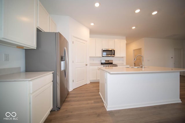 5607 Tart Blvd, Indianapolis, IN 46239 - kitchen with stainless steel appliances, white cabinetry, a kitchen island with sink, recessed lighting, and wood finished floors