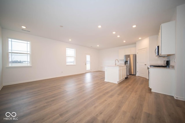 5607 Tart Blvd, Indianapolis, IN 46239 - unfurnished living room with wood finished floors and recessed lighting