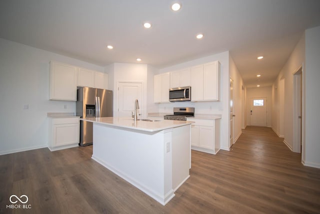 5607 Tart Blvd, Indianapolis, IN 46239 - kitchen featuring appliances with stainless steel finishes, a kitchen island with sink, dark wood-style flooring, white cabinetry, and light countertops