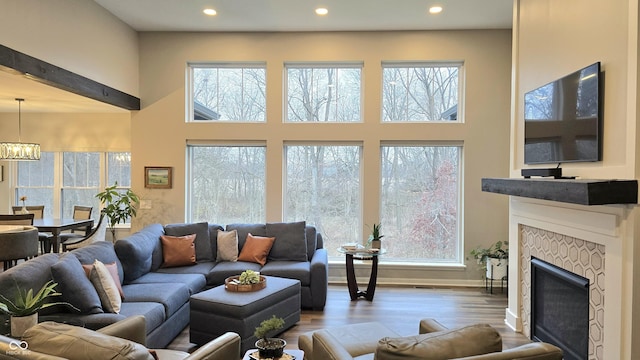 living room with a fireplace, a chandelier, and hardwood / wood-style flooring