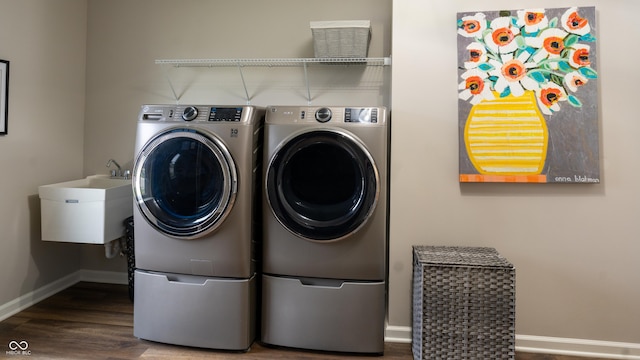 washroom with sink, washer and dryer, and wood-type flooring