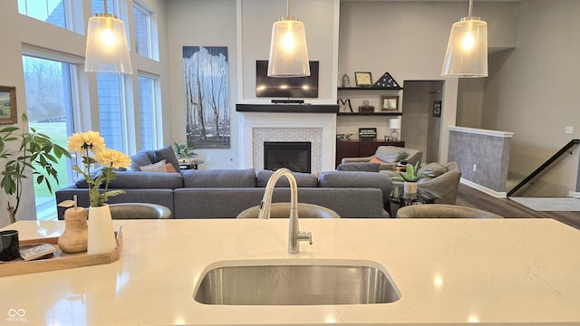 living room with a tile fireplace and sink