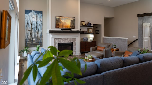 living room featuring hardwood / wood-style flooring and a tiled fireplace