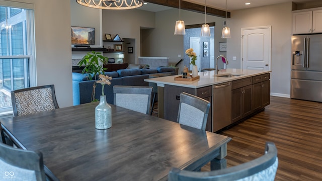 dining space featuring beamed ceiling, dark hardwood / wood-style flooring, and sink