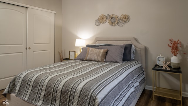 bedroom with dark hardwood / wood-style flooring and a closet