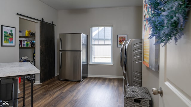 kitchen featuring a barn door, stainless steel fridge, dark hardwood / wood-style flooring, and a wealth of natural light