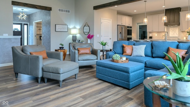 living room with sink, dark wood-type flooring, and a notable chandelier