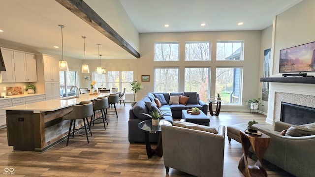 living room with a tile fireplace, sink, a chandelier, and dark hardwood / wood-style floors