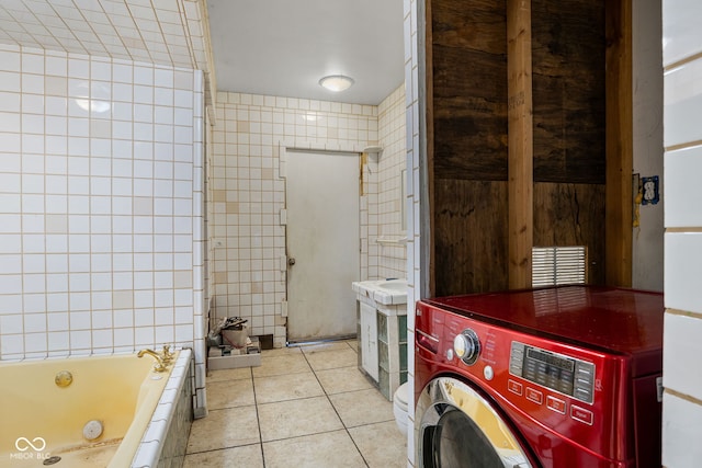 bathroom featuring tile patterned floors, a washtub, tile walls, and washer / clothes dryer