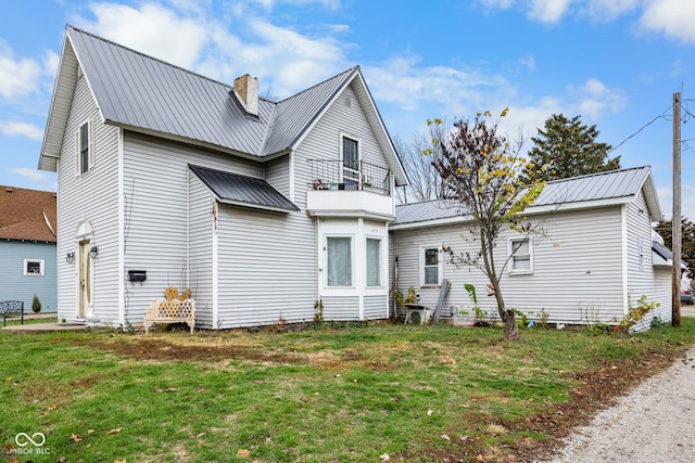 rear view of house featuring a lawn