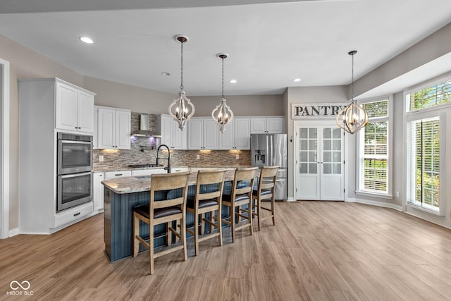 10346 Strongbow Rd, Fishers, IN 46040 - kitchen with stainless steel appliances, a chandelier, wall chimney range hood, white cabinets, and recessed lighting