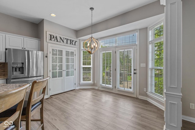 10346 Strongbow Rd, Fishers, IN 46040 - unfurnished dining area featuring a chandelier, light wood finished floors, recessed lighting, french doors, and ornate columns