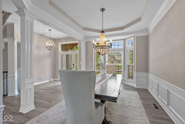 10346 Strongbow Rd, Fishers, IN 46040 - dining space with a chandelier, decorative columns, a decorative wall, dark wood-style flooring, and a wainscoted wall