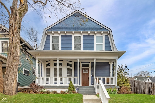 view of front of property featuring covered porch and a front lawn