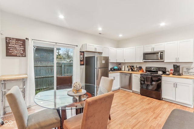 kitchen featuring white cabinetry, light hardwood / wood-style floors, and appliances with stainless steel finishes