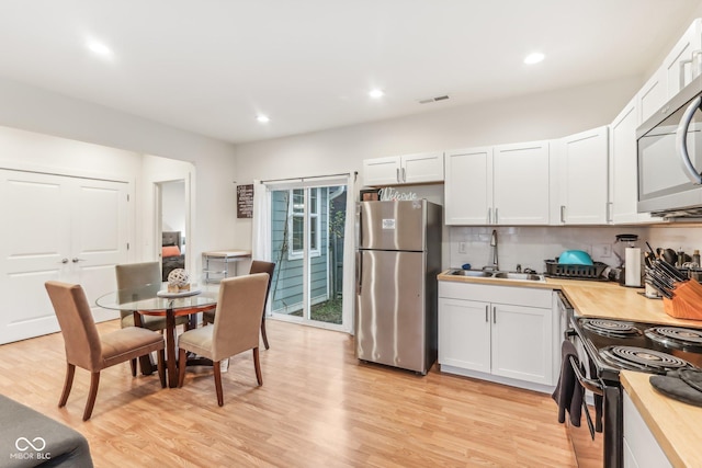 359 Terrace Ave, Indianapolis, IN 46225 - kitchen with backsplash, light wood-style flooring, stainless steel appliances, and a sink