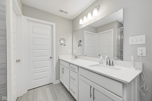 bathroom with vanity and a shower with door