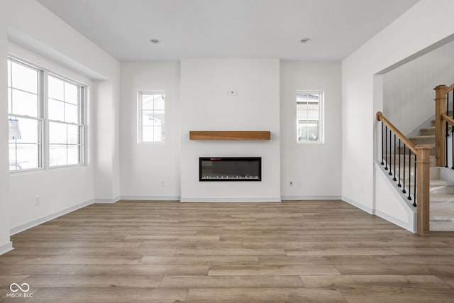 unfurnished living room with light hardwood / wood-style flooring and plenty of natural light