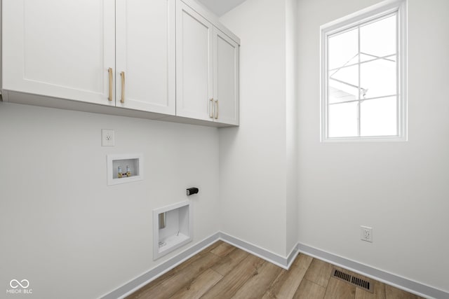 washroom with cabinets, a healthy amount of sunlight, electric dryer hookup, and washer hookup