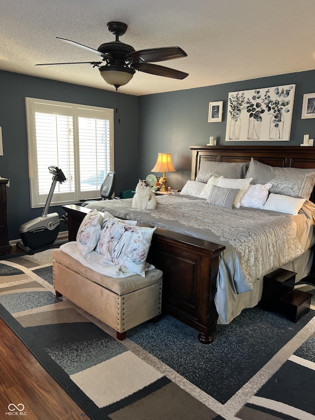 bedroom featuring wood-type flooring, a textured ceiling, and ceiling fan