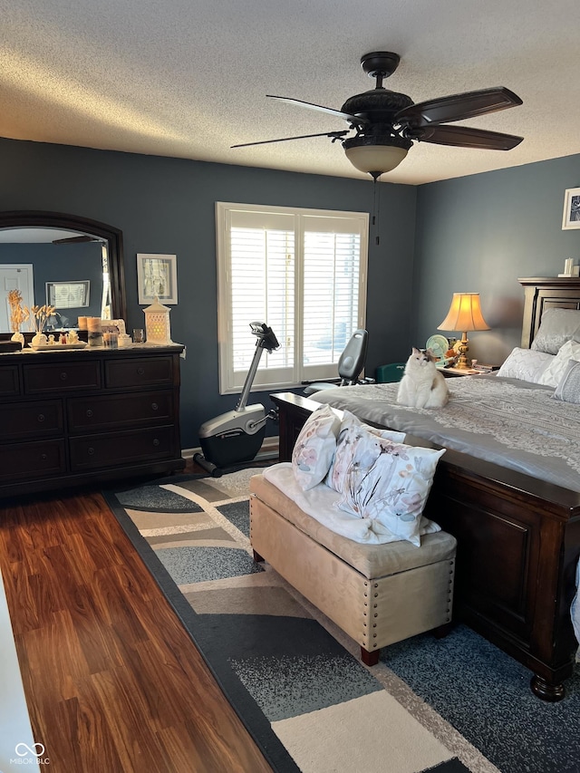 bedroom featuring a textured ceiling, ceiling fan, and dark wood-type flooring