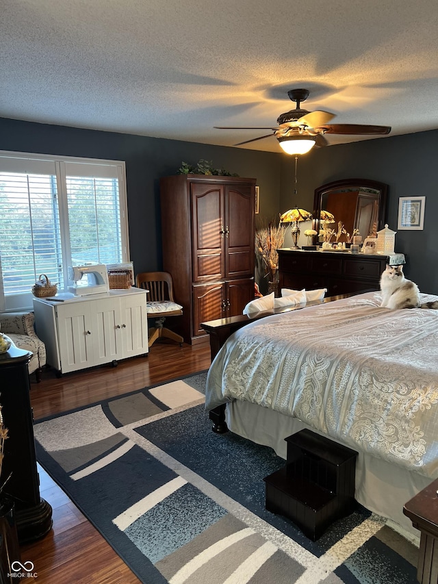 bedroom featuring hardwood / wood-style floors, ceiling fan, and a textured ceiling