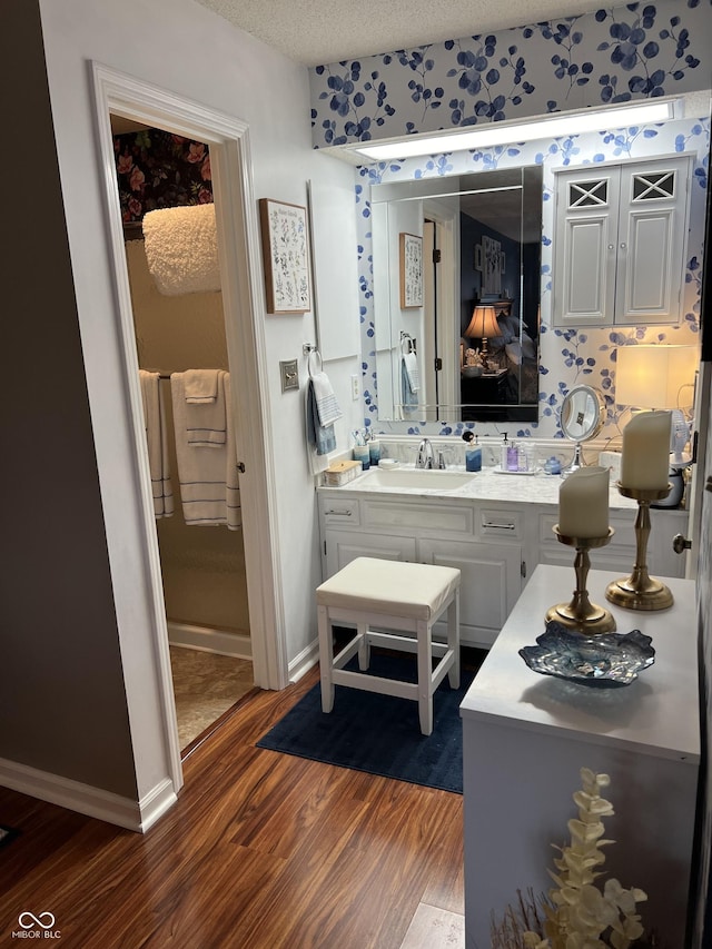 bathroom featuring hardwood / wood-style flooring, vanity, and a textured ceiling