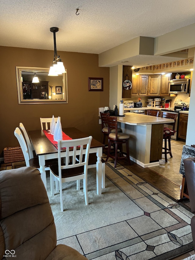 dining area featuring light hardwood / wood-style floors and a textured ceiling