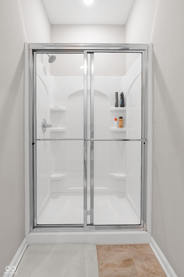 bathroom with a shower with door